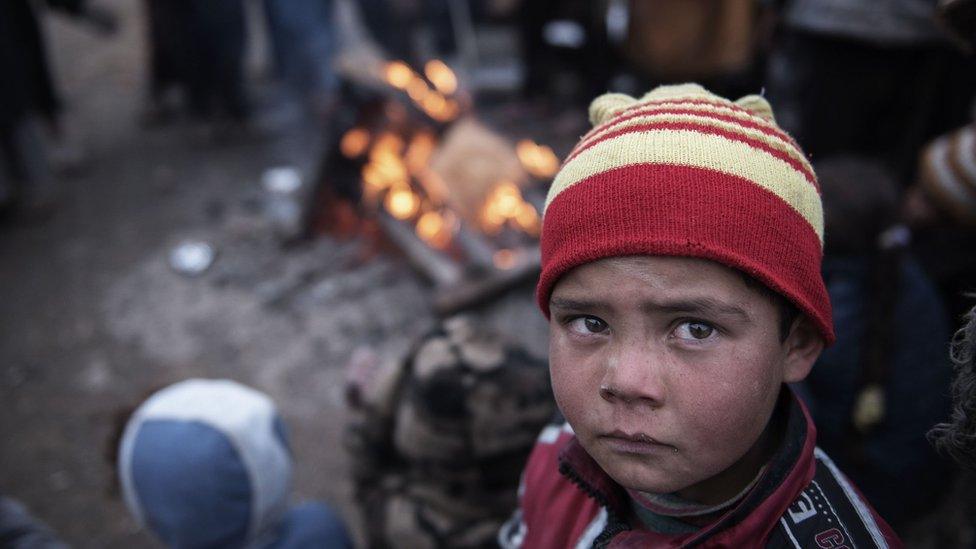 A child stands by a fire after fleeing fighting between IS and Iraqi security forces in Tall Kaysumah, west of Mosul, Iraq, 4 March 2017