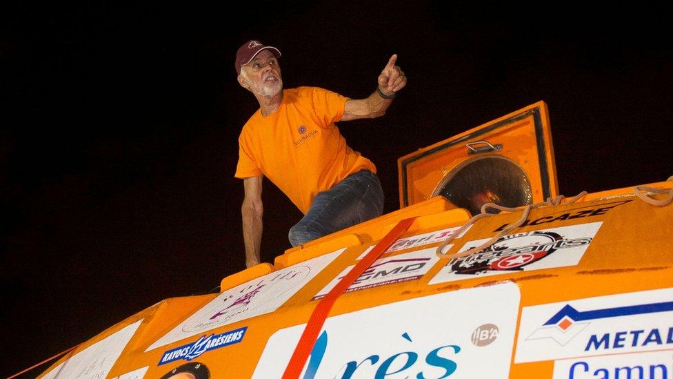 Jean-Jacques Savin is seen on top of his custom-made barrel after landing on the French Caribbean island of Martinique