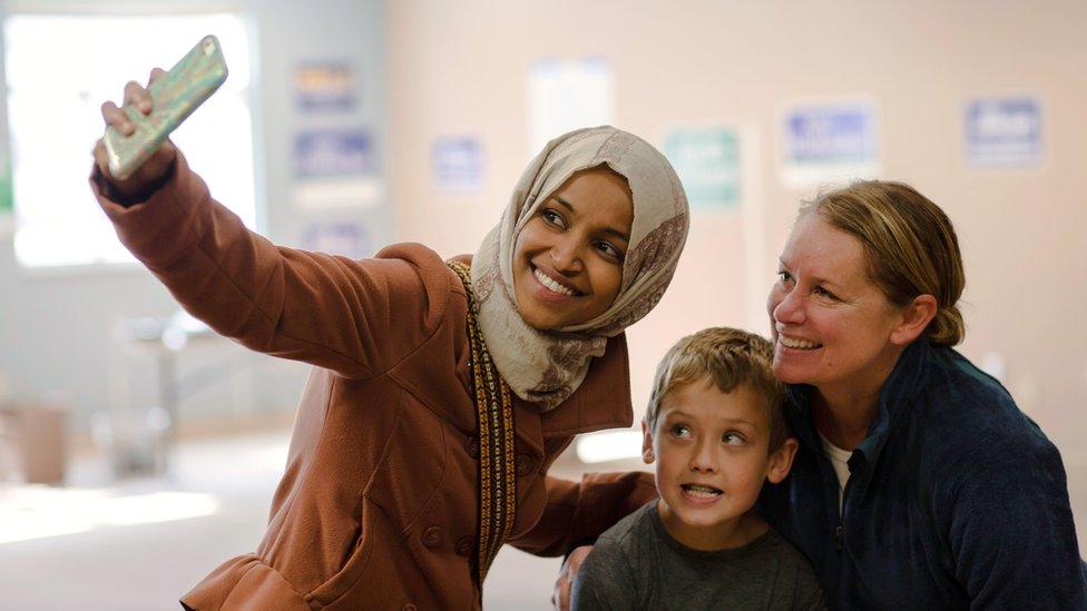 Ilhan Omar, Democratic congressional candidate, poses for a selfie with a supporter and her son while campaigning in Minneapolis, Minnesota, on October 13, 2018. -