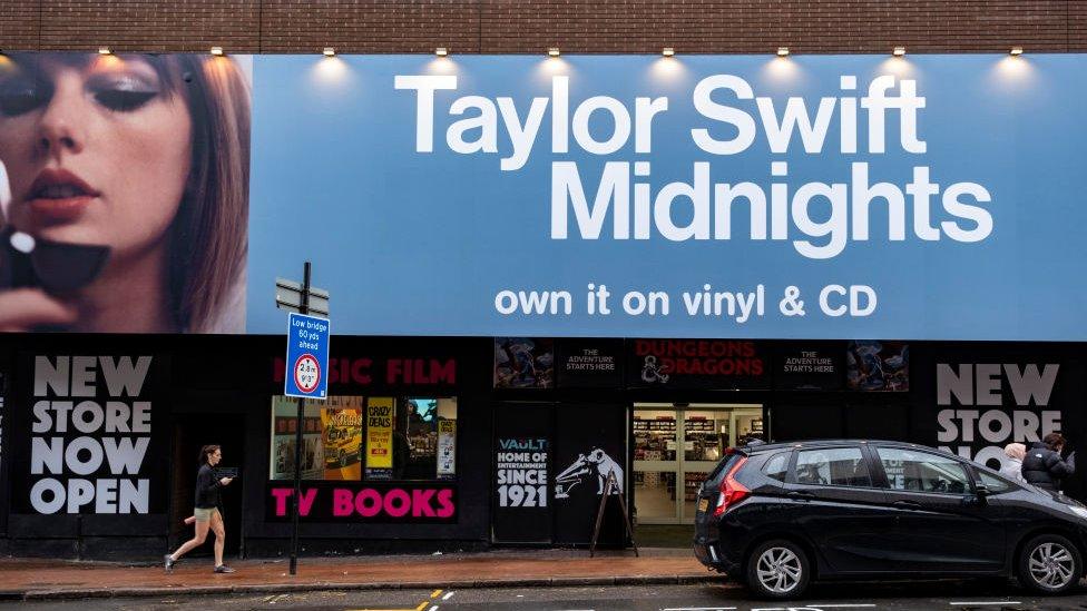 a billboard for midnights on the wall of an hmv shop in the UK