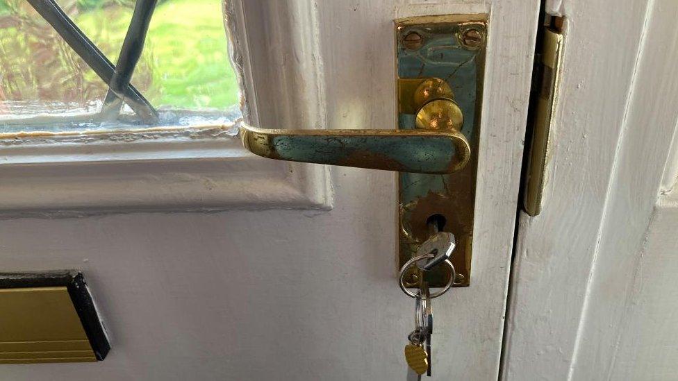 Front door of house showing keys in lock