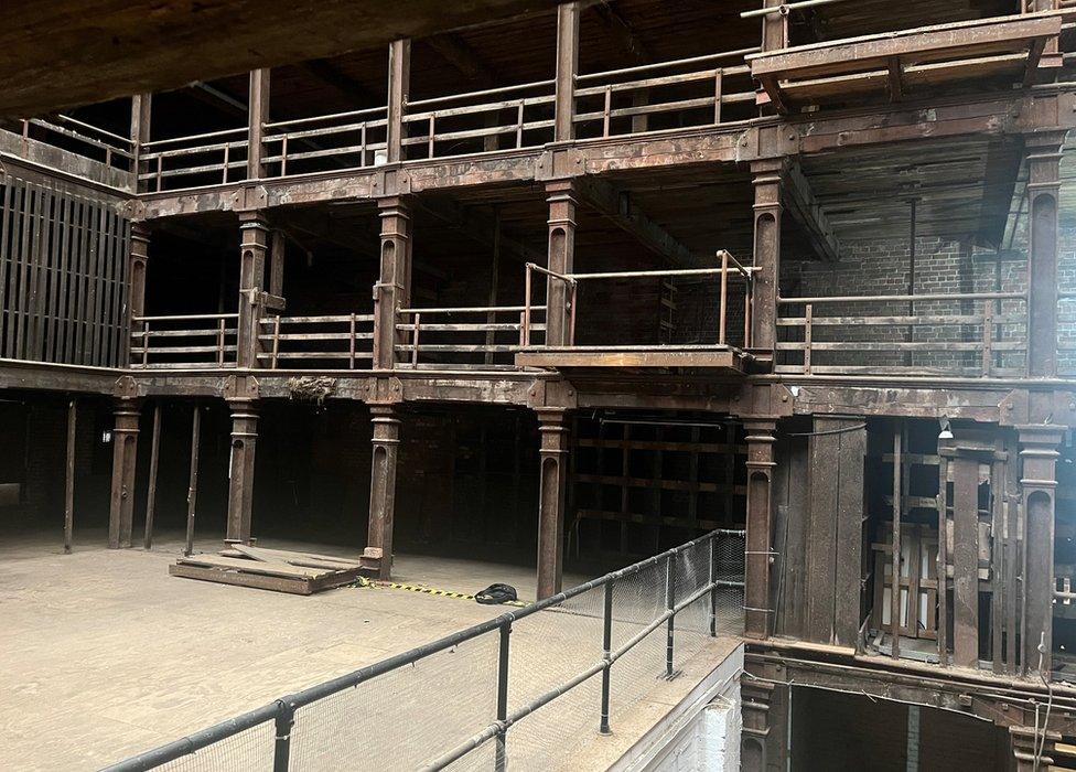 An interior image of the "unique atrium" with galleries held up by cast iron columns in a glass-roofed courtyard