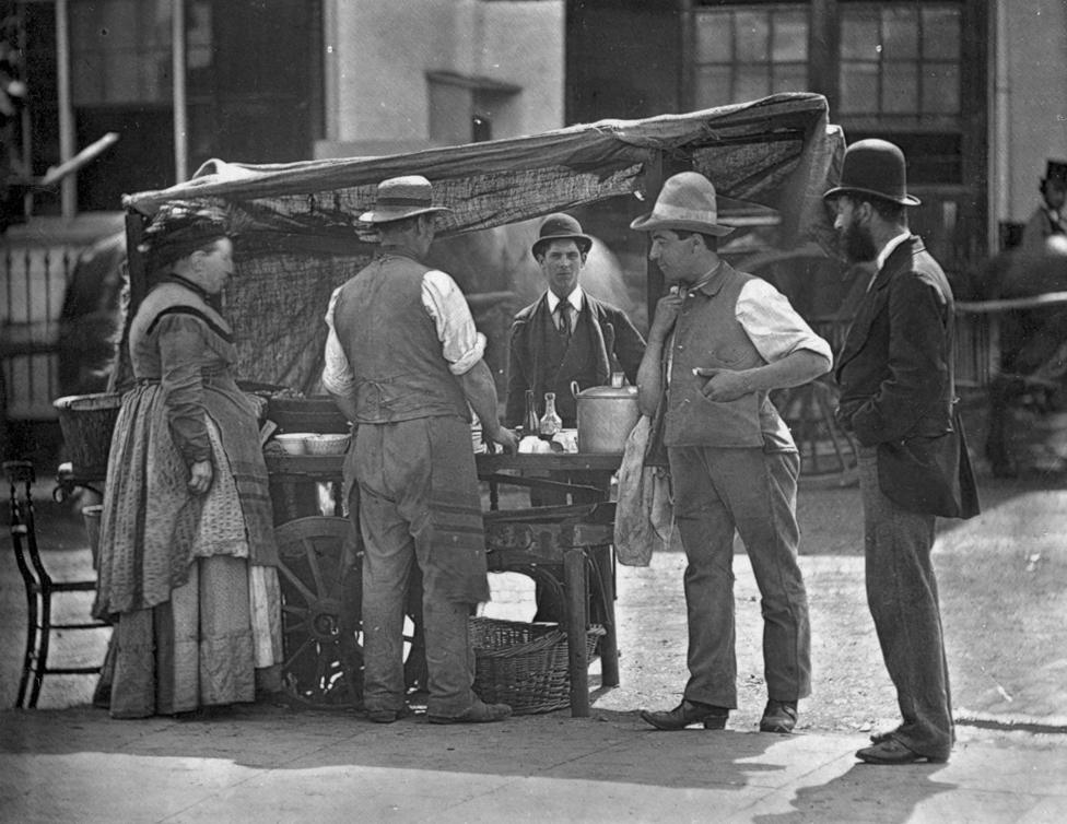 A Victorian shellfish stall holder selling oysters and whelks.