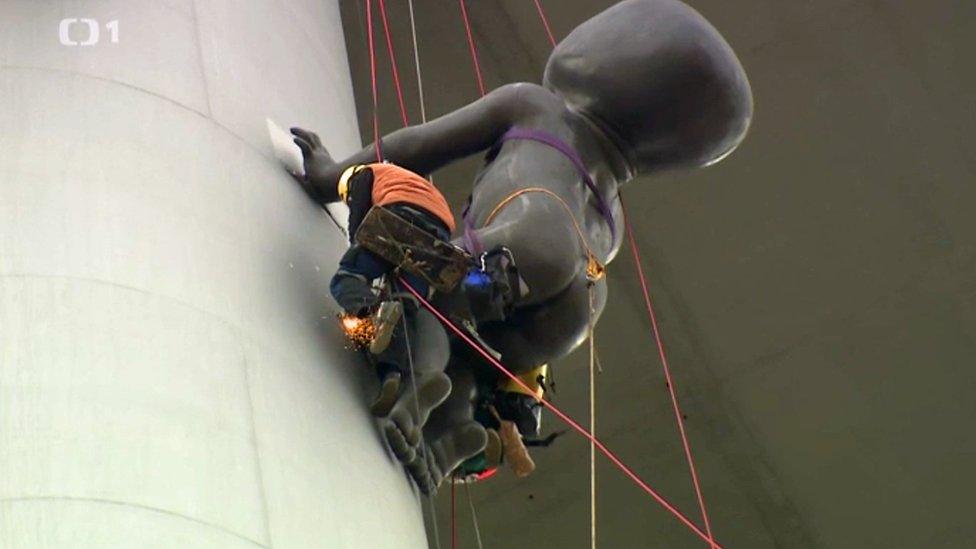 Work to remove one of the babies on the Zizkov tower