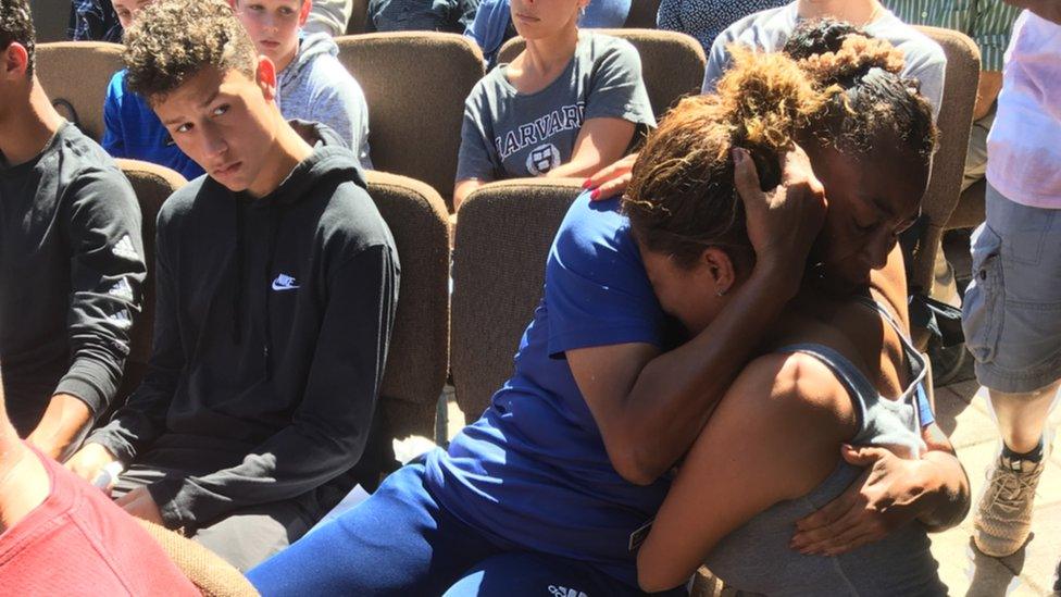 Two people embracing in tears at the vigil