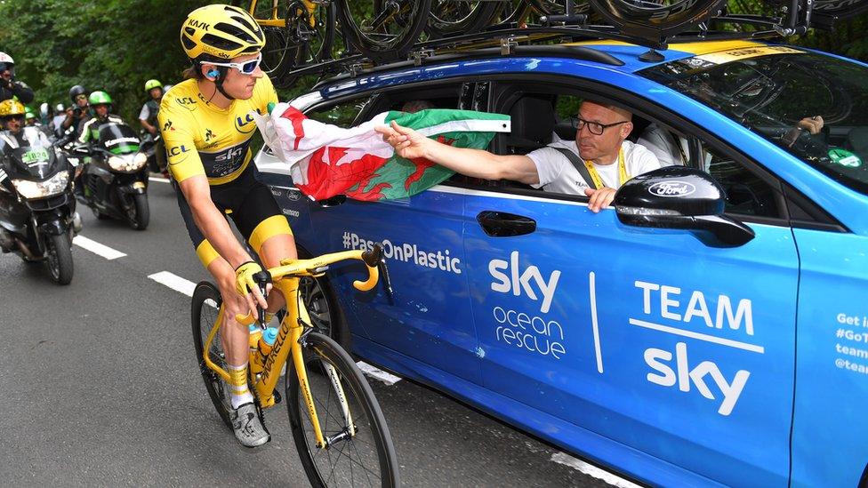 Geraint Thomas accepting a Welsh flag from Sir David Brailsford