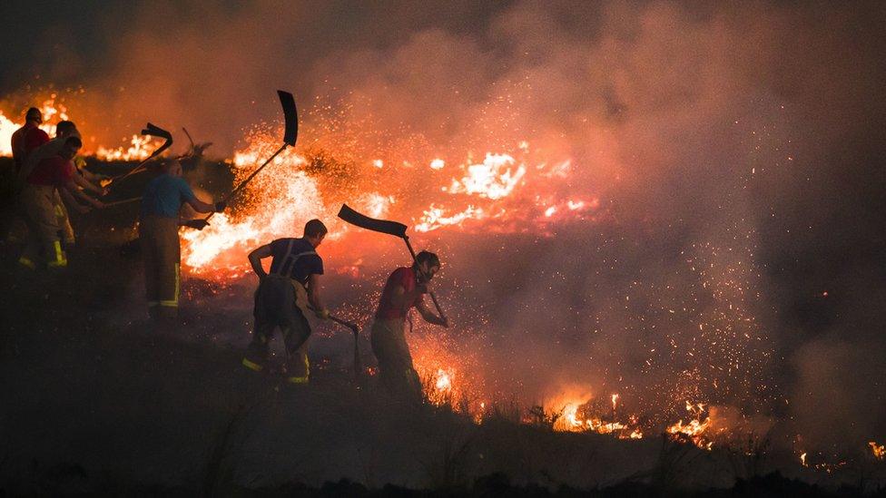 Firefighters at night try to extinguish flames