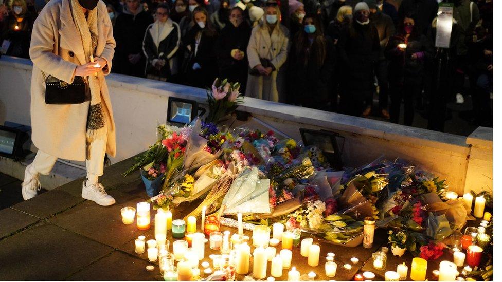 Floral tributes and candles are left after a vigil outside the London Irish Centre in Camden in memory of murdered primary school teacher