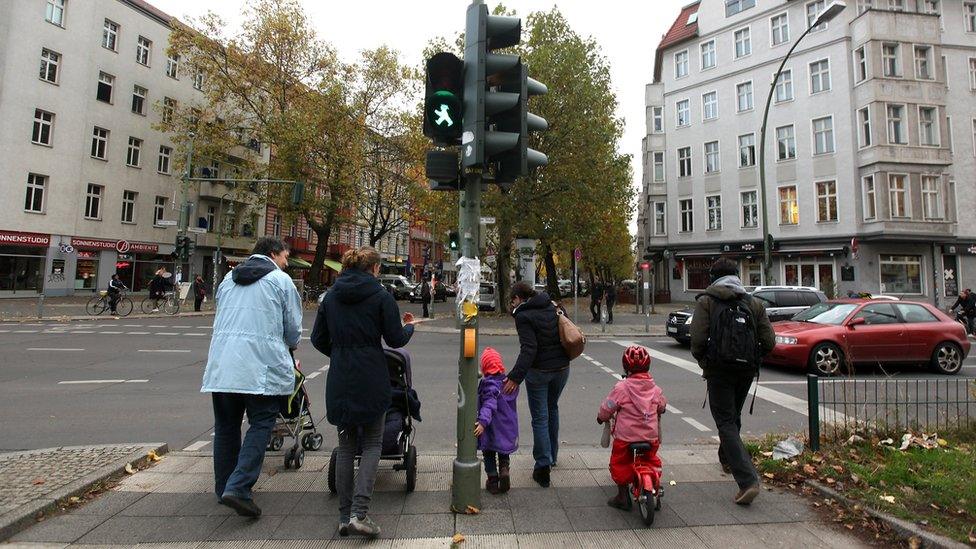 A group of parents and children cross the street in the former East German neighbourhood of Prenzlauer Berg