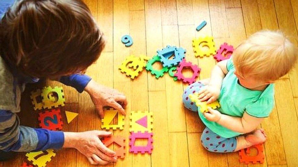 A grandparent plays with a young boy