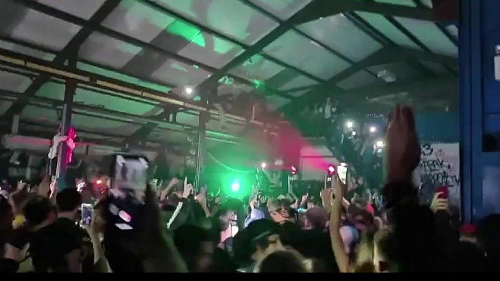 Hundreds of people are dancing and filming themselves on their phones in a warehouse in Yate.