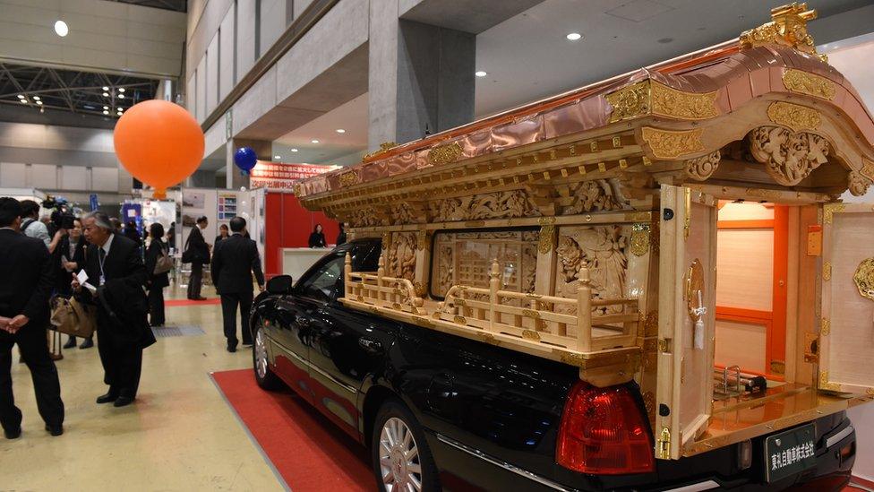 A hearse decorated with a traditional Japanese shrine