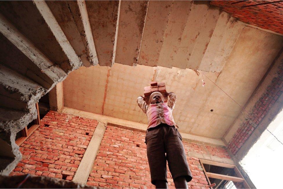 Ram Bhavan at a construction site carrying bricks