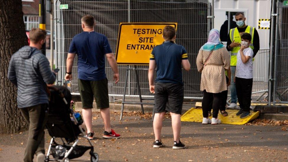 Members of the public queue at a coronavirus testing facility in Sutton Coldfield