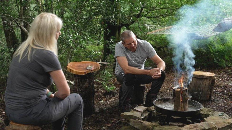 Iain and Helen Rich, sitting by a campfire