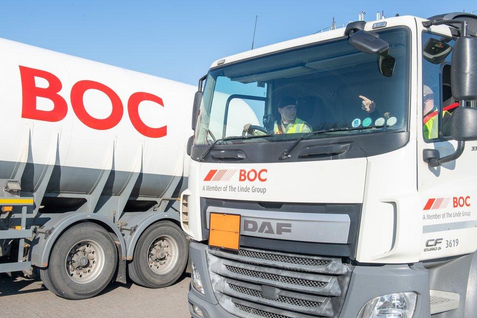 A soldier drives a lorry delivering oxygen to a hospital