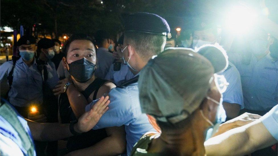 Officers detain a man outside Victoria Park