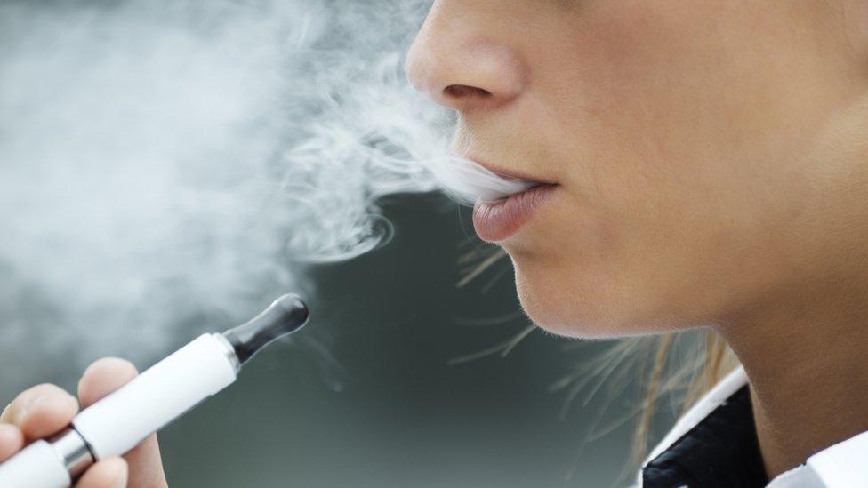 A close up of a woman vaping