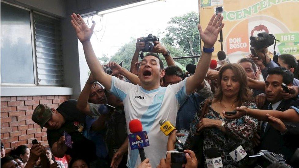 Jimmy Morales gestures while addressing the media next to his wife Gilda Marroquin after casting his vote at a polling station in Guatemala City on 25 October, 2015