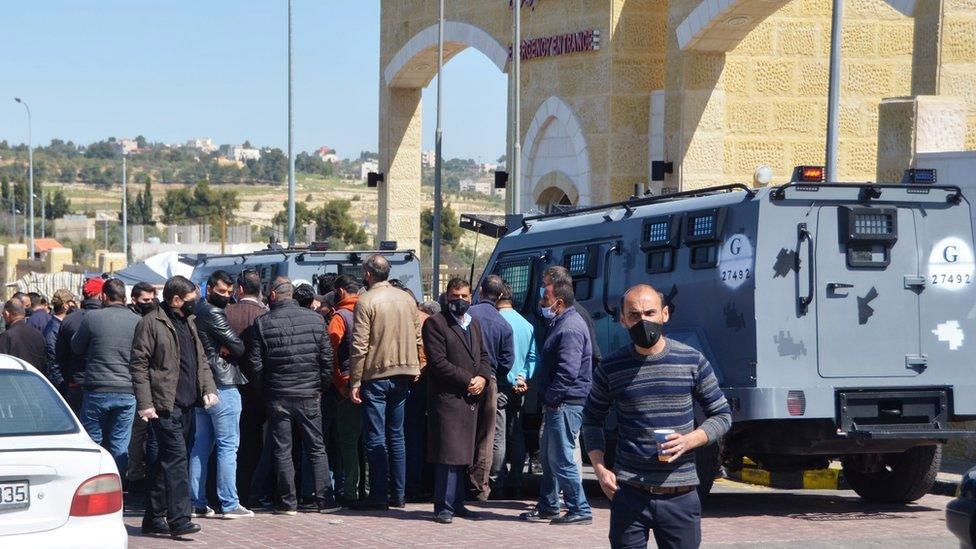 People gather outside the new Salt government hospital in Jordan, 13 March 2021