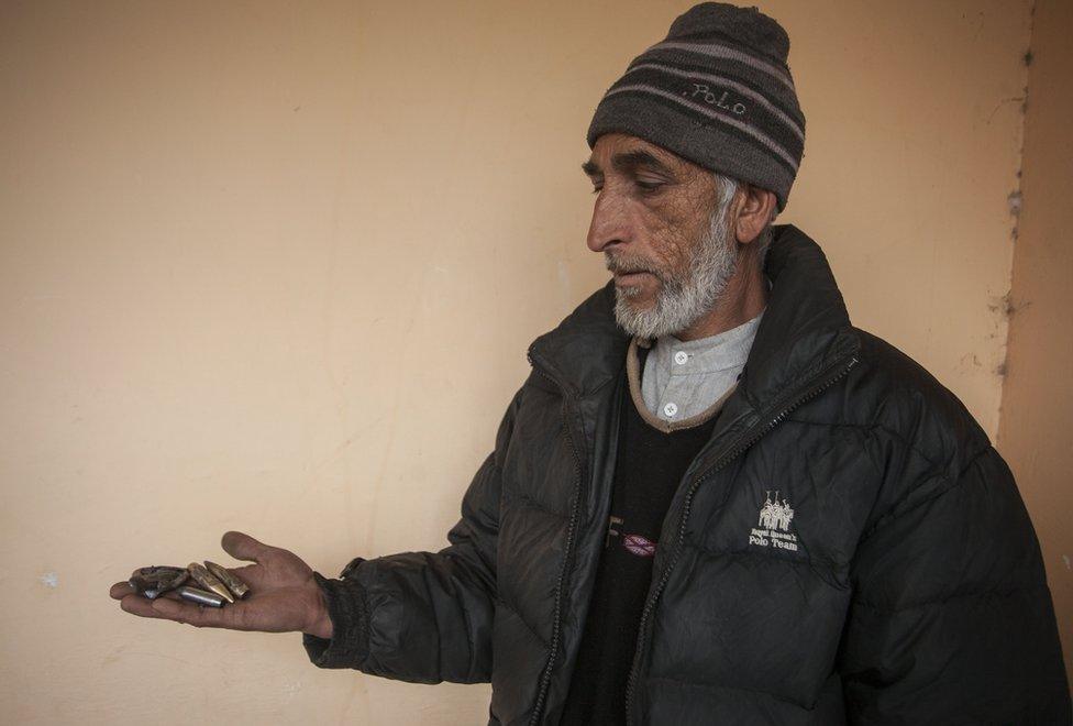 Mohammad Yaqoob holds empty bullet shells in his palm.