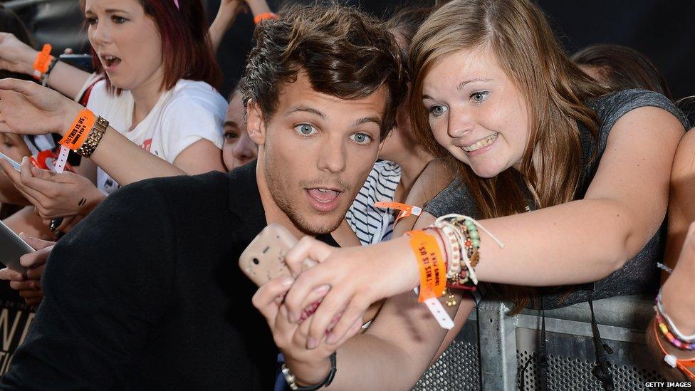 1D's Louis Tomlinson taking pictures with Directioners