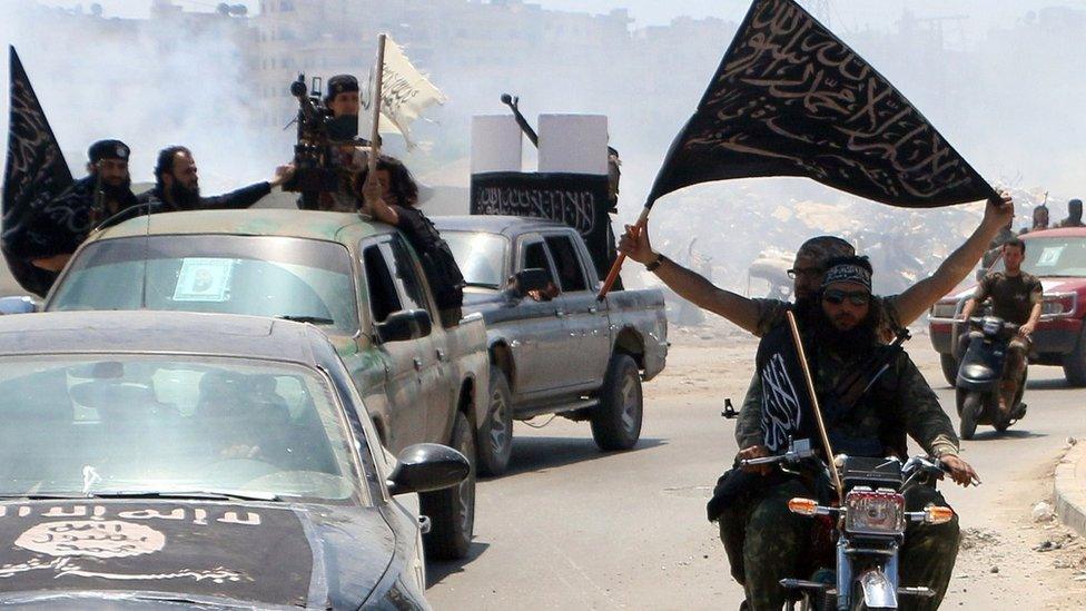 Fighters from Al-Nusra Front drive in Aleppo flying Islamist flags as they head to a front line, on May 26, 2015