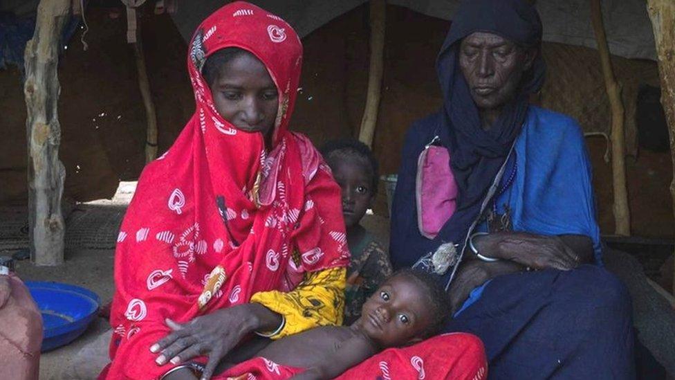 Fatima (R) and her daughter (L) who has one of her children cradled in her lap