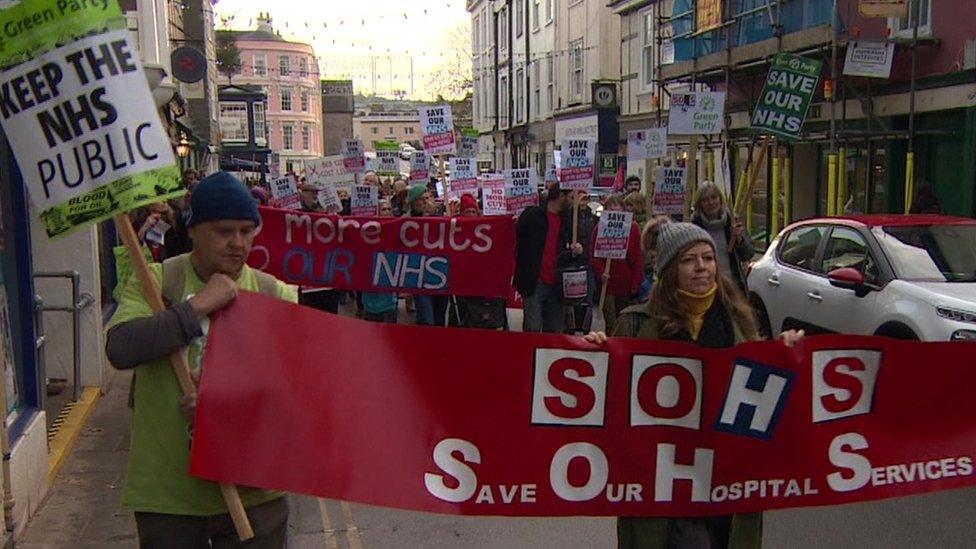 Protestors carrying an 'SOHS' banner