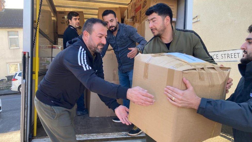 Volunteers filling the back of a van with supplies