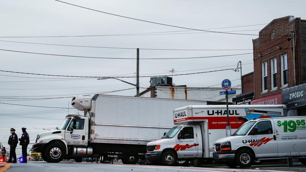 Police stand by trucks filled with dead bodies in New York