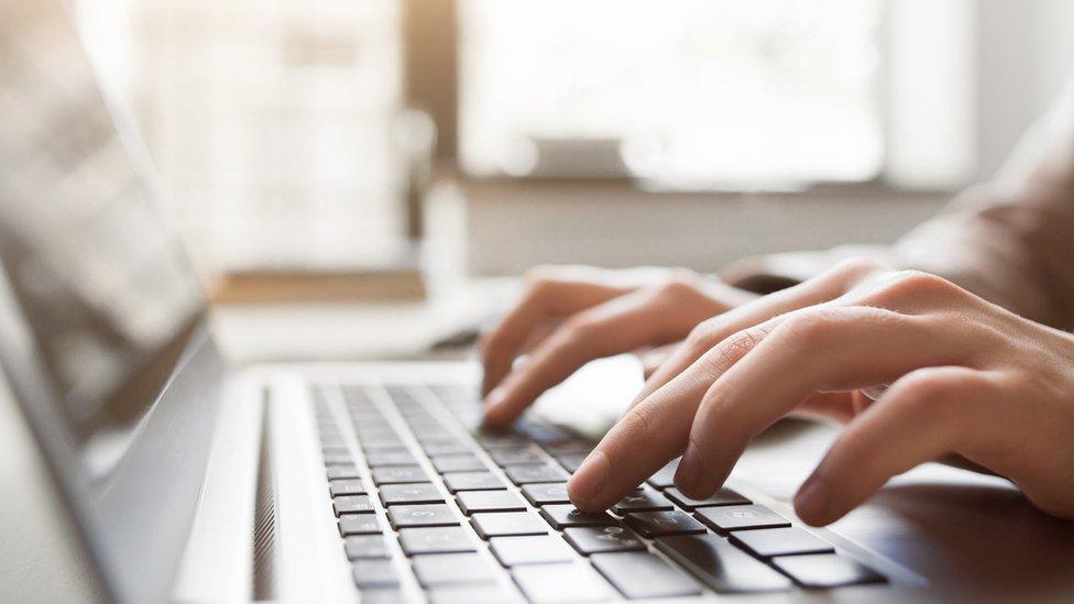 Person typing on computer keyboard