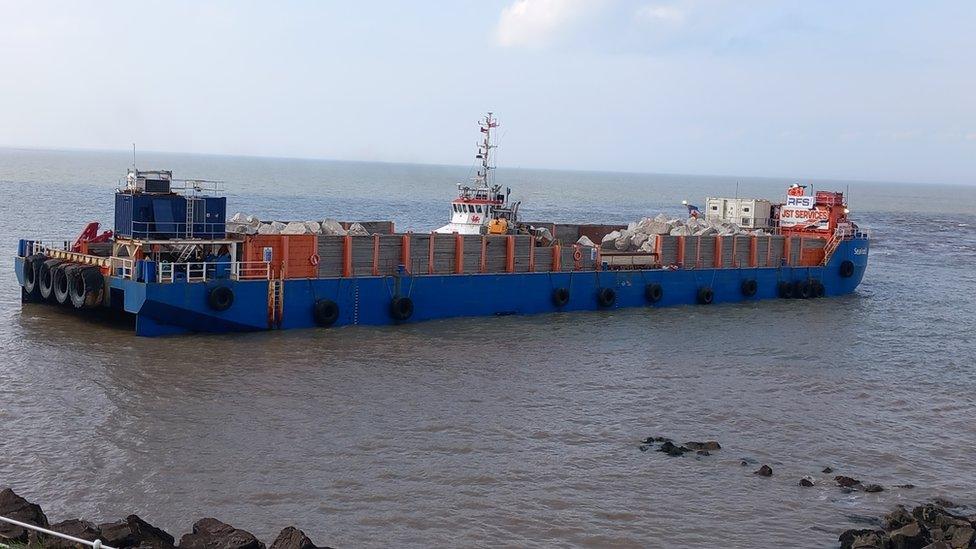 A blue barge full of rocks