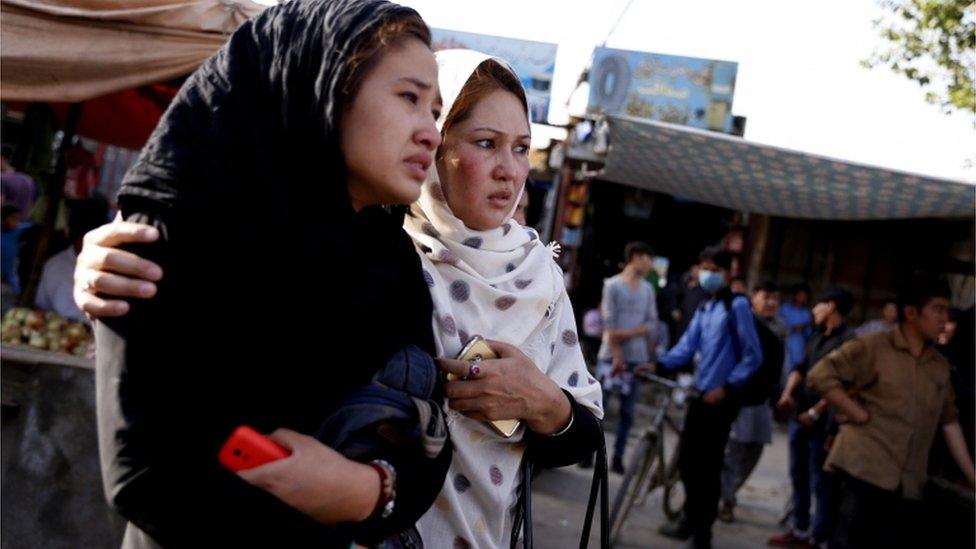 Two women look on to the blast scene