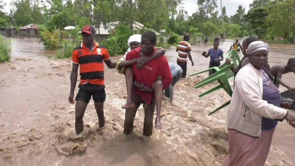 Man carrying a woman in a flood