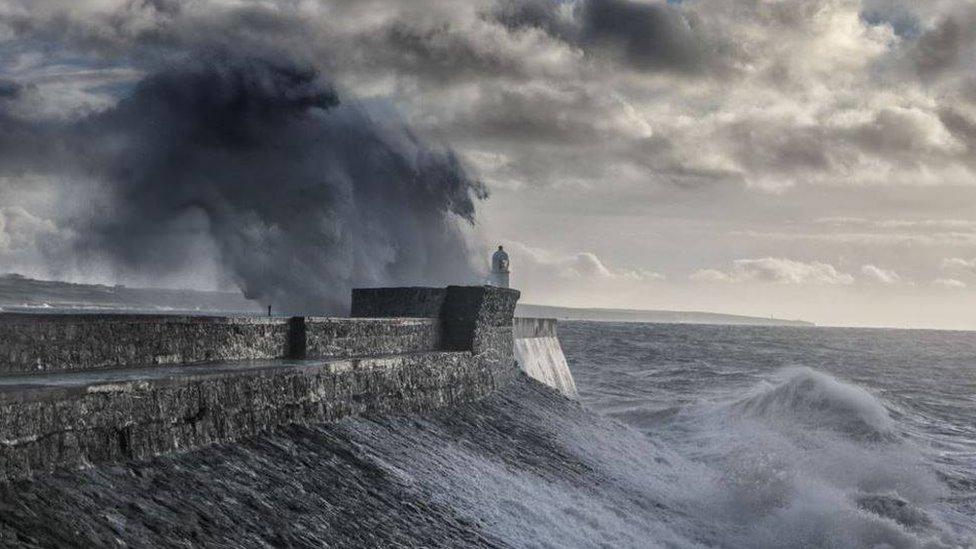 Large waves crashed against Porthcawl lighthouse in Bridgend county on Friday when a weather warning for wind was in place