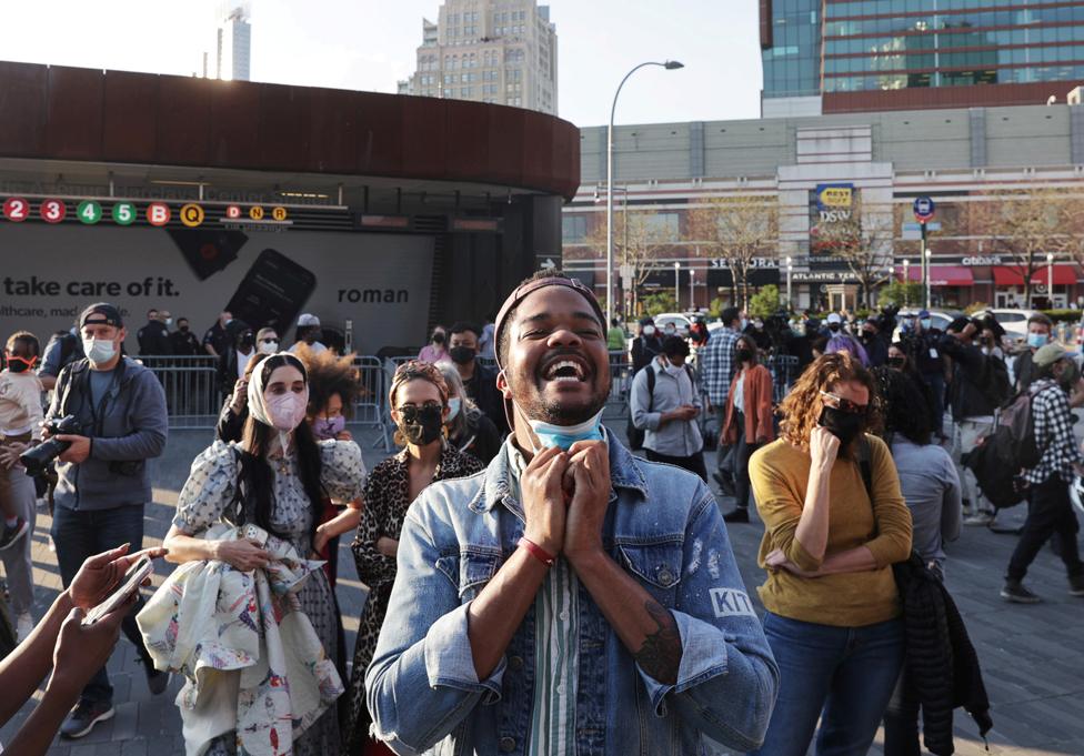 A person pulls their mask down and smiles, after the verdict in the trial of former Minneapolis police officer Derek Chauvin, at the Barclays Center in Brooklyn, New York City, 20 April 2021