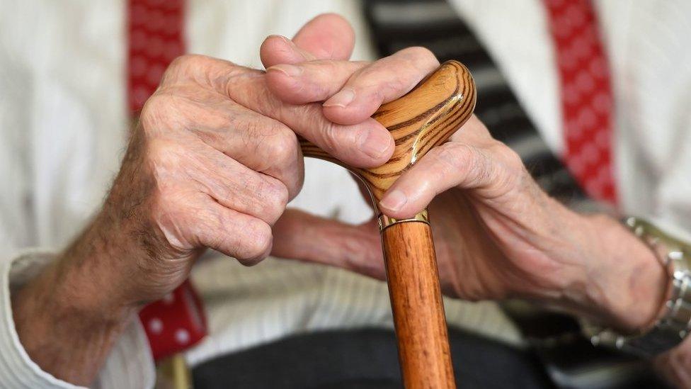 Old man holding walking stick