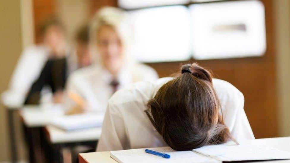 Teenager with head on desk