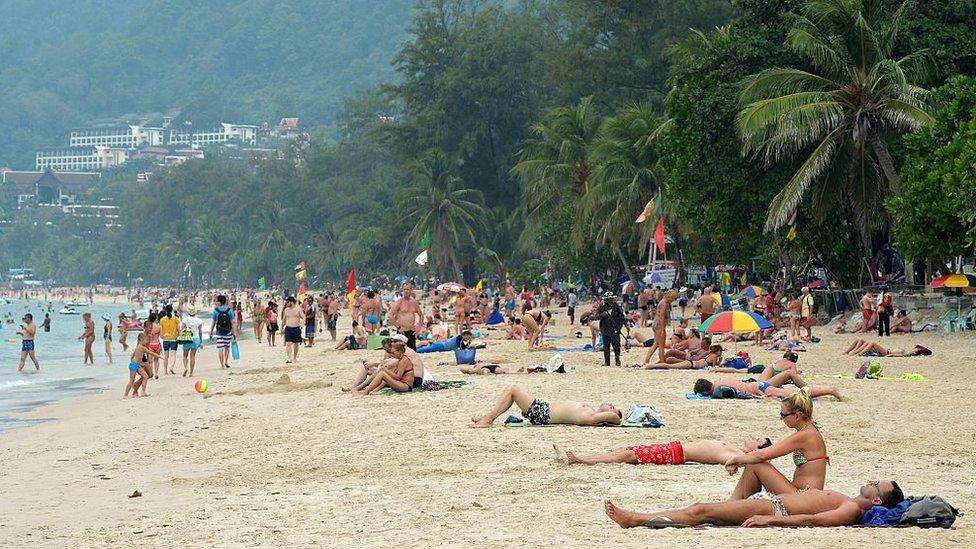 Foreign tourists relax at Patong beach in Thailand's Phuket province