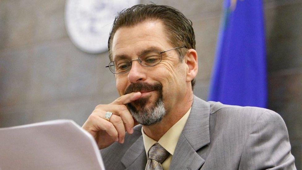 Bruce Fromong smiles as he reads a piece of paper in court