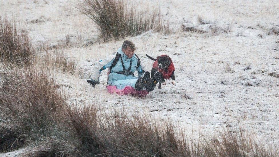 A woman sledging in the Brecon Beacons