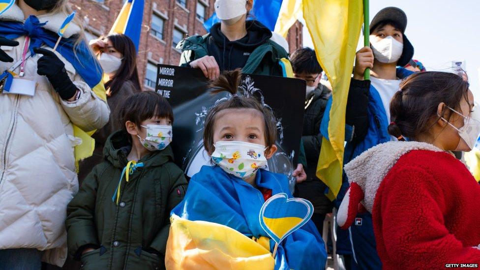 A photo of a child wrapped in a Ukrainian flag