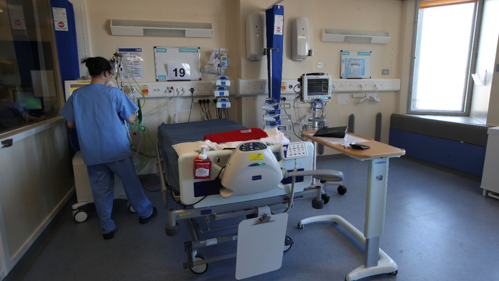 A nurse working at a hospital bed