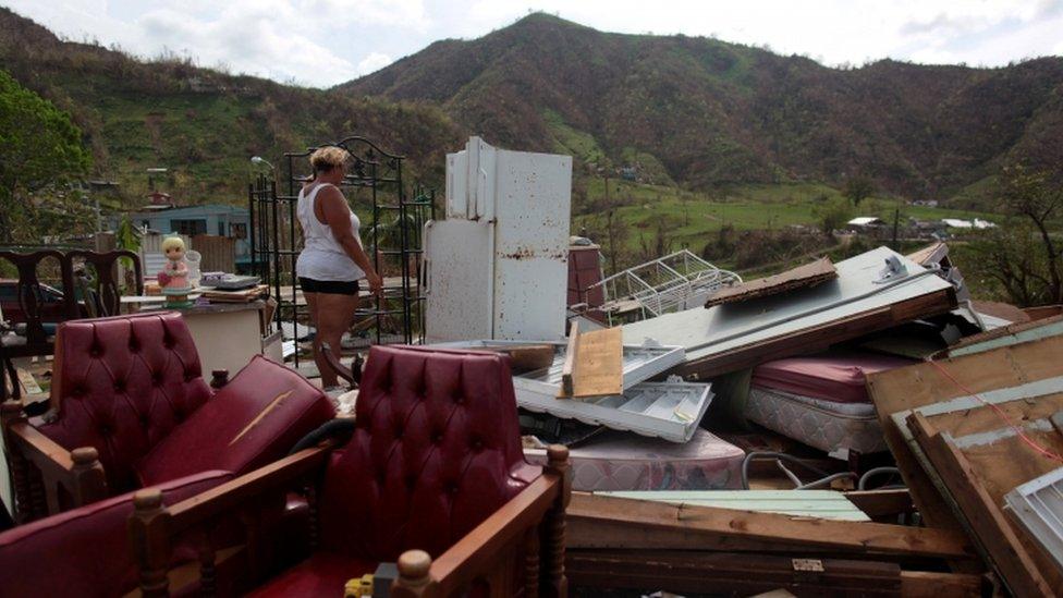 woman near destroyed home