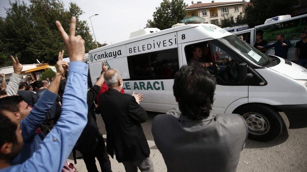 Mourners display the V-sign and applaud as an ambulance carrying a victim of Saturdays bombing attack leaves a hospital's morgue for a funeral procession, in Ankara (11 October 2015)