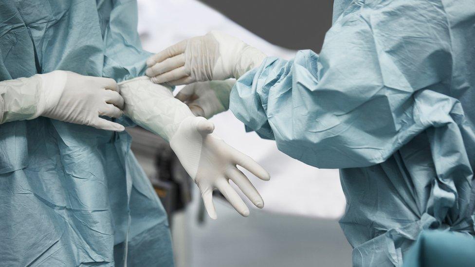 Surgeons putting on gloves