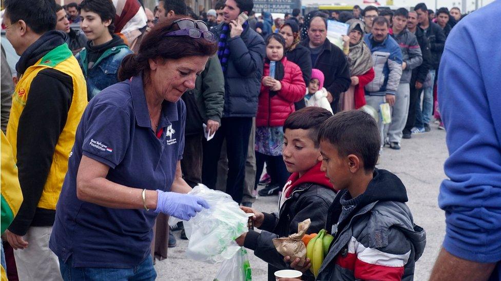 Aid worker with migrants in Piraeus, near Athens