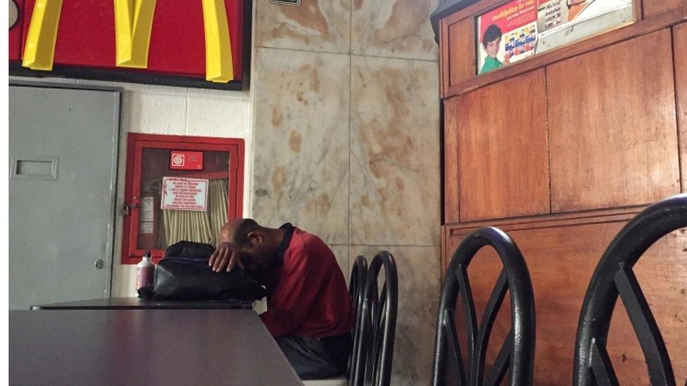 A man rests in a closed down restaurant during the power cut