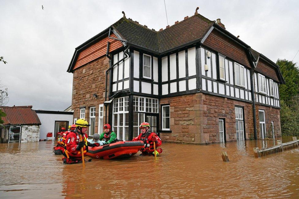 Mountain Rescue team members rescue Peter Morgan from his house which has been flooded in Monmouth.